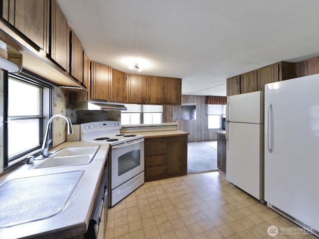 20725 9th Ave E Unit 6, Spanaway, WA 98387 - kitchen with white appliances, light countertops, light floors, wooden walls, and brown cabinetry