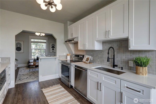 3225 Oakes Ave, Everett, WA 98201 - kitchen with appliances with stainless steel finishes, under cabinet range hood, arched walkways, and white cabinetry