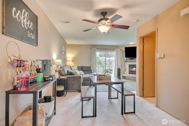 1450 Mountain View Dr, Enumclaw, WA 98022 - living area with light colored carpet, a ceiling fan, and a lit fireplace