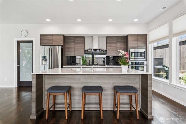 12914 SE 213th, Kent, WA 98031 - kitchen with appliances with stainless steel finishes, wall chimney exhaust hood, modern cabinets, a spacious island, and recessed lighting