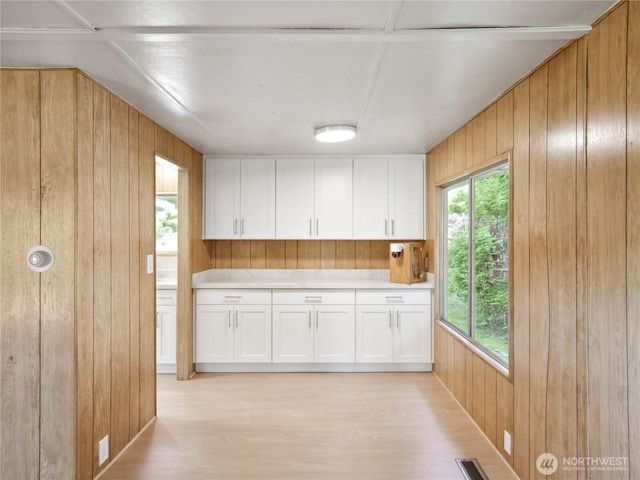 9128 184th Ave NE, Granite Falls, WA 98252 - kitchen with wood walls, light countertops, plenty of natural light, light wood finished floors, and white cabinets
