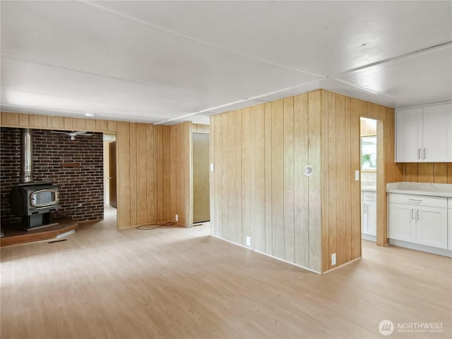 9128 184th Ave NE, Granite Falls, WA 98252 - unfurnished living room with a wood stove, light wood-type flooring, and wood walls
