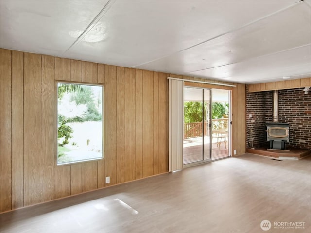 9128 184th Ave NE, Granite Falls, WA 98252 - unfurnished living room featuring a wood stove, plenty of natural light, wood walls, and wood finished floors