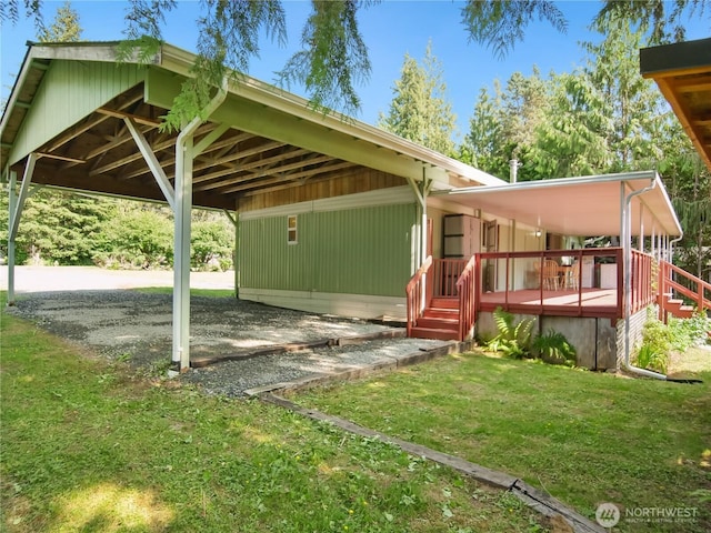 9128 184th Ave NE, Granite Falls, WA 98252 - view of front of home featuring a carport, a front lawn, a wooden deck, and gravel driveway