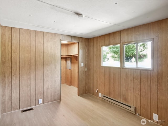 9128 184th Ave NE, Granite Falls, WA 98252 - unfurnished bedroom featuring a baseboard radiator, wood finished floors, a spacious closet, wood walls, and a closet
