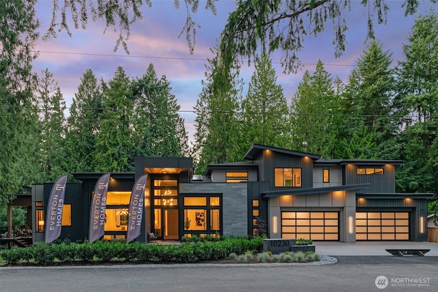 10230 SE 13th Pl, Bellevue, WA 98004 - contemporary house featuring asphalt driveway, an attached garage, and board and batten siding
