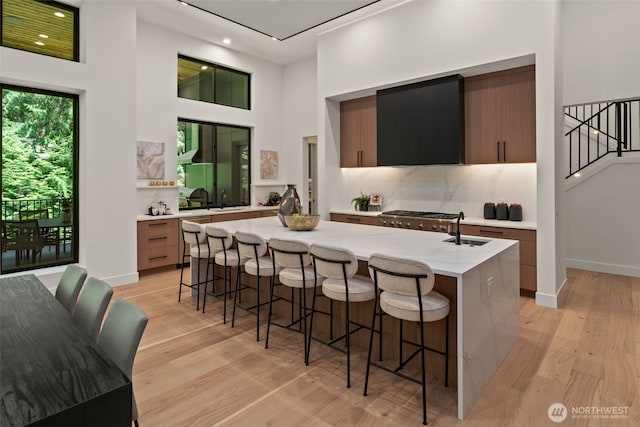 10230 SE 13th Pl, Bellevue, WA 98004 - kitchen featuring modern cabinets, range hood, light wood-type flooring, a towering ceiling, and recessed lighting