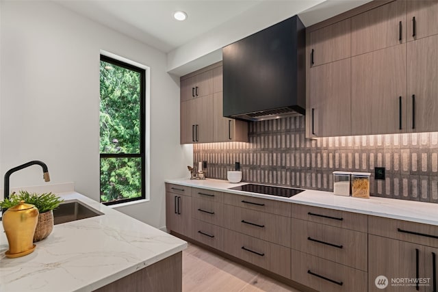 10230 SE 13th Pl, Bellevue, WA 98004 - kitchen with black electric cooktop, range hood, tasteful backsplash, light stone countertops, and light wood-type flooring