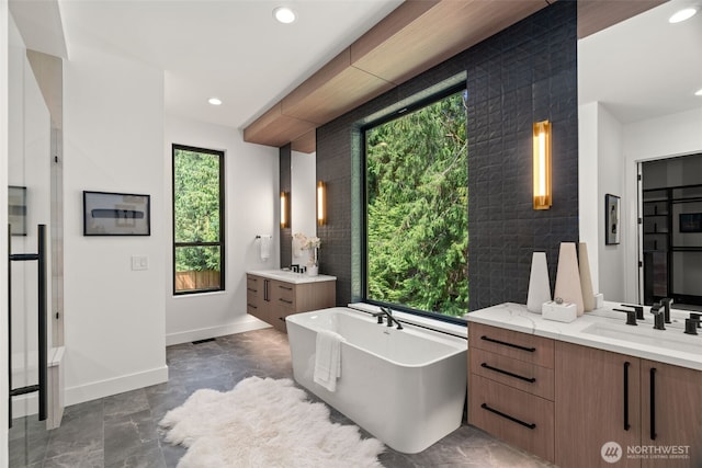 10230 SE 13th Pl, Bellevue, WA 98004 - bathroom featuring two vanities, a freestanding bath, and recessed lighting