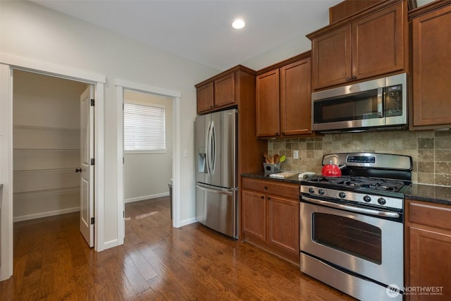2504 NE 24th Pl, Renton, WA 98056 - kitchen featuring appliances with stainless steel finishes, backsplash, dark wood-type flooring, brown cabinets, and recessed lighting