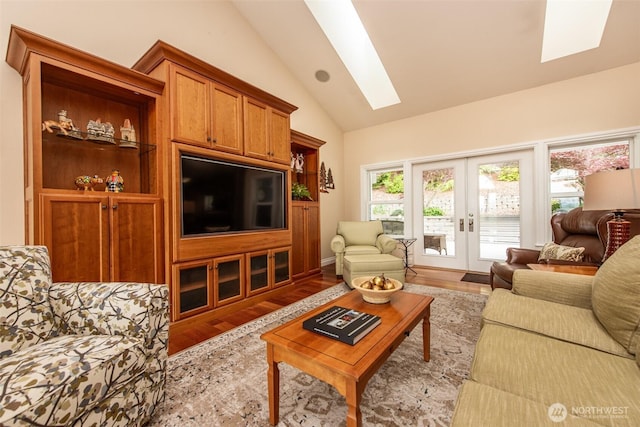 1483 Fox Hollow Rd, Sequim, WA 98382 - living room featuring a skylight, wood finished floors, healthy amount of natural light, french doors, and high vaulted ceiling