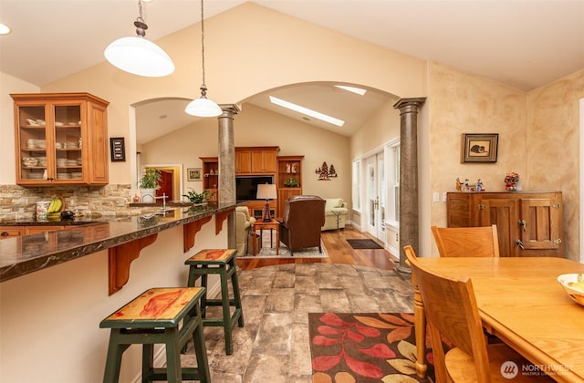 1483 Fox Hollow Rd, Sequim, WA 98382 - dining room featuring lofted ceiling, arched walkways, decorative columns, and wood finished floors