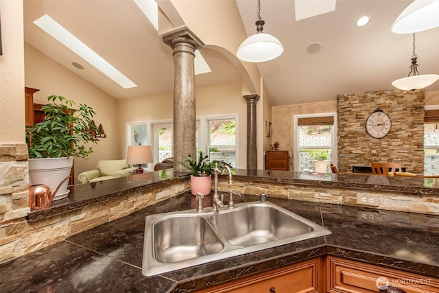 1483 Fox Hollow Rd, Sequim, WA 98382 - kitchen with vaulted ceiling, ornate columns, open floor plan, pendant lighting, and brown cabinets
