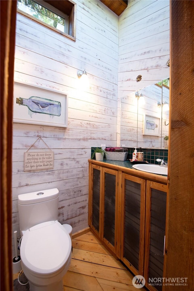 251 Saddle Dr, Port Townsend, WA 98368 - bathroom featuring wooden walls, vanity, and wood-type flooring