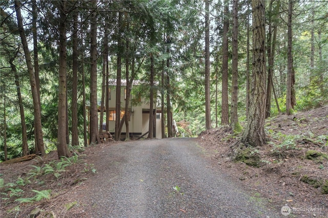 251 Saddle Dr, Port Townsend, WA 98368 - view of front facade featuring a forest view, gravel driveway, and an outdoor structure