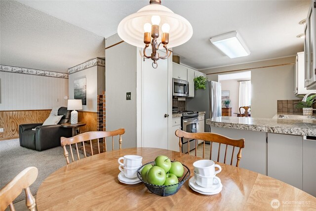 1021 Garden Dr, Lynden, WA 98264 - carpeted dining space featuring wallpapered walls and a wainscoted wall