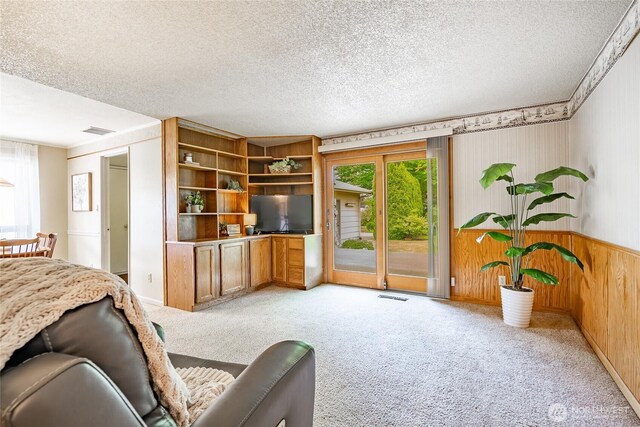 1021 Garden Dr, Lynden, WA 98264 - living room featuring light carpet, a textured ceiling, wood walls, and a wainscoted wall