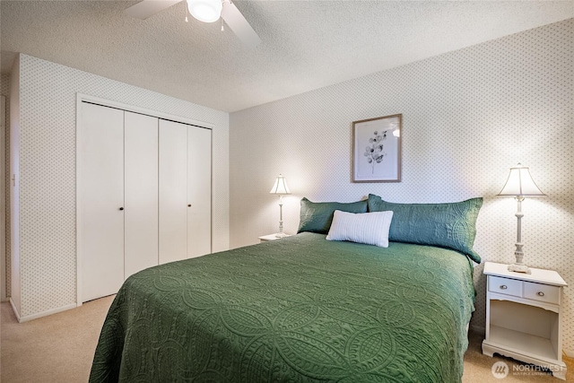 1021 Garden Dr, Lynden, WA 98264 - carpeted bedroom with wallpapered walls, a closet, a ceiling fan, and a textured ceiling