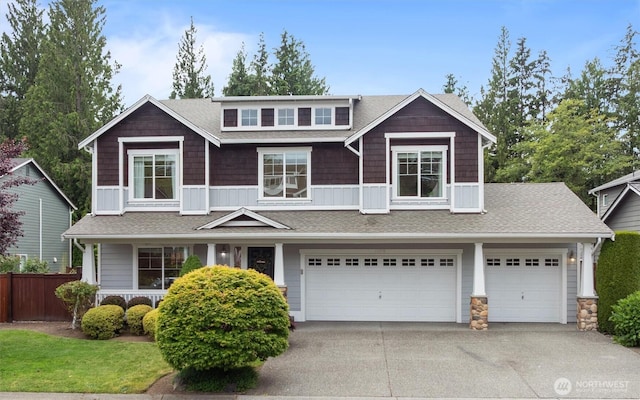 14219 284th Pl NE, Duvall, WA 98019 - craftsman house with driveway, an attached garage, a shingled roof, and stone siding