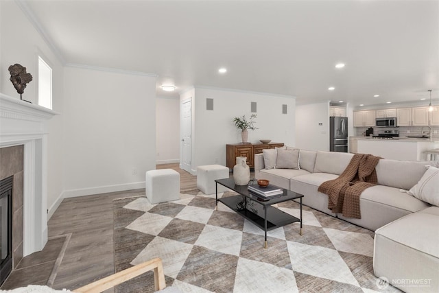 14219 284th Pl NE, Duvall, WA 98019 - living area featuring recessed lighting, a tiled fireplace, ornamental molding, and light wood-style flooring