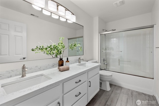 14219 284th Pl NE, Duvall, WA 98019 - full bath featuring double vanity, wood finished floors, shower / bath combination with glass door, and decorative backsplash