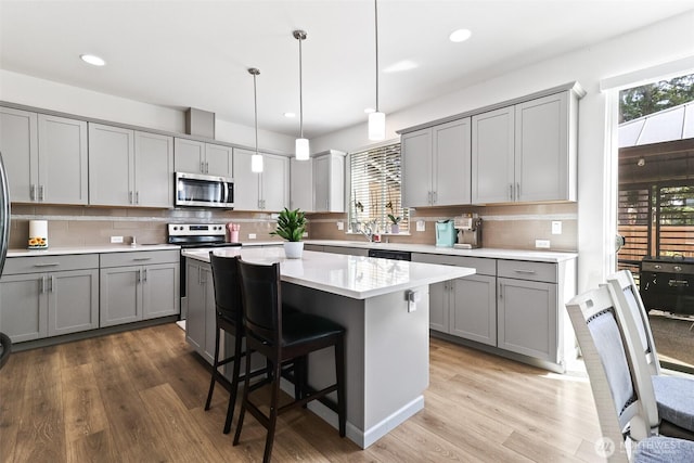 202 191st Street Ct E, Spanaway, WA 98387 - kitchen with stainless steel appliances, gray cabinetry, light countertops, a kitchen island, and backsplash