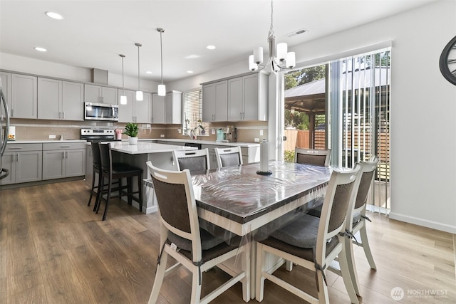 202 191st Street Ct E, Spanaway, WA 98387 - dining room with wood finished floors, a chandelier, and recessed lighting