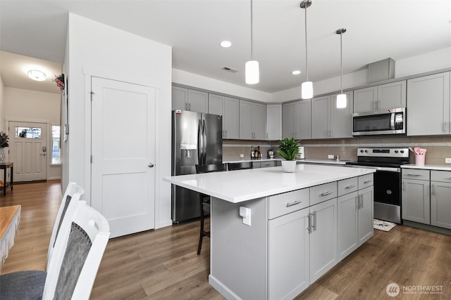 202 191st Street Ct E, Spanaway, WA 98387 - kitchen featuring stainless steel appliances, gray cabinets, wood finished floors, a kitchen island, and recessed lighting