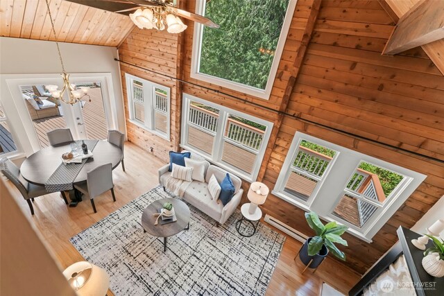 12170 Viewcrest Pl NE, Bainbridge Island, WA 98110 - living area featuring wooden ceiling, a chandelier, wood finished floors, wood walls, and high vaulted ceiling