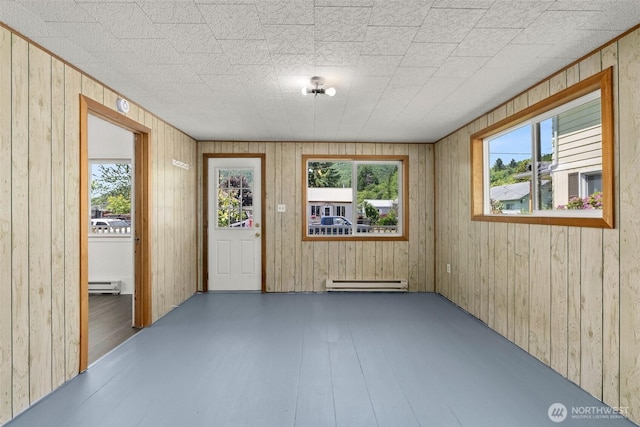 1211 Larch St, Raymond, WA 98577 - unfurnished room featuring baseboard heating, wooden walls, and wood finished floors