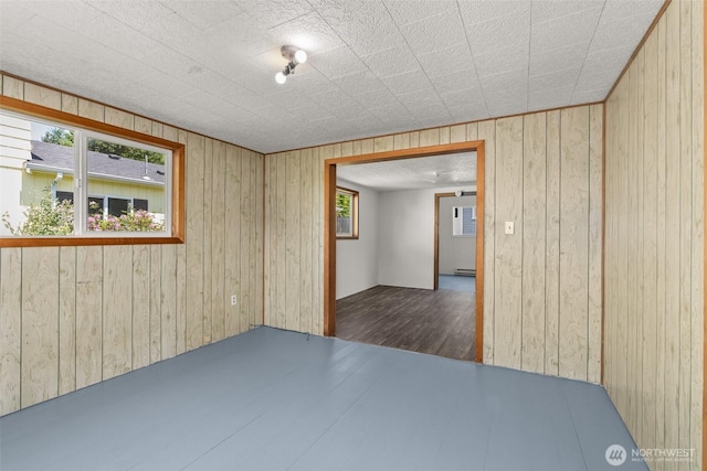 1211 Larch St, Raymond, WA 98577 - spare room with wood walls, a baseboard heating unit, and wood finished floors