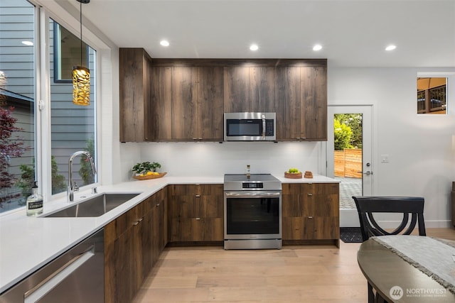 2665 51st Ave SW, Seattle, WA 98116 - kitchen featuring appliances with stainless steel finishes, modern cabinets, light wood-style floors, light countertops, and recessed lighting