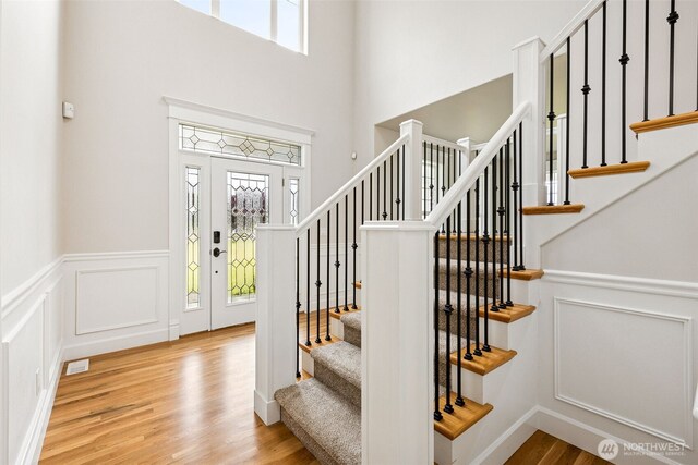 14808 172nd St E, Orting, WA 98360 - foyer entrance featuring wood finished floors, a decorative wall, wainscoting, stairs, and a towering ceiling
