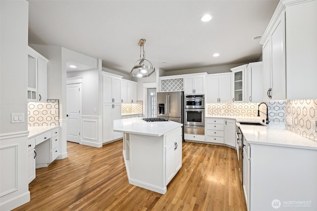 14808 172nd St E, Orting, WA 98360 - kitchen featuring a warming drawer, stainless steel appliances, backsplash, a center island, and light wood-style floors