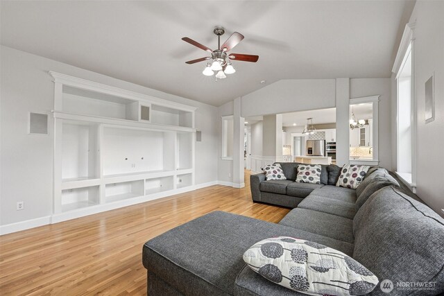14808 172nd St E, Orting, WA 98360 - living area with light wood-style flooring, a ceiling fan, lofted ceiling, built in features, and a chandelier