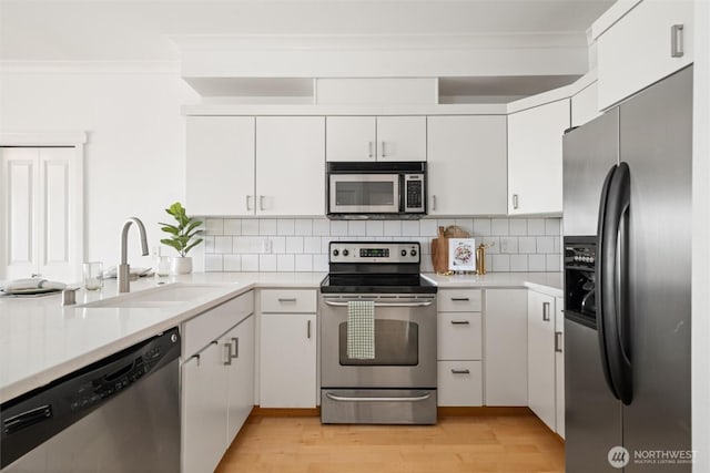 1015 Railroad Ave Unit 518, Bellingham, WA 98225 - kitchen with stainless steel appliances, ornamental molding, light wood-style floors, and light countertops