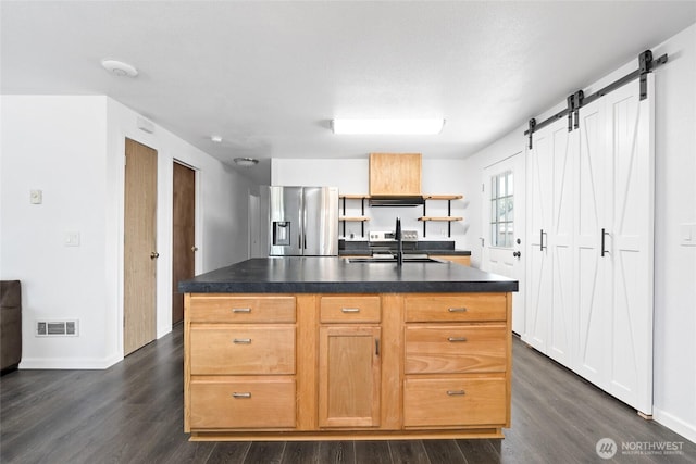 307 Brown St SE, Orting, WA 98360 - kitchen with stainless steel fridge with ice dispenser, dark countertops, dark wood-type flooring, and a barn door