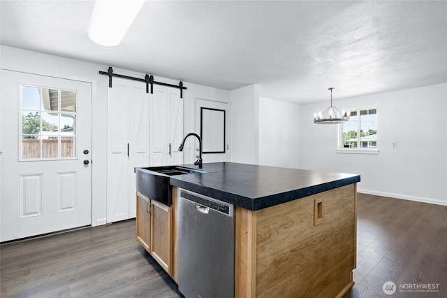 307 Brown St SE, Orting, WA 98360 - kitchen featuring stainless steel dishwasher, dark countertops, dark wood finished floors, a barn door, and a kitchen island with sink