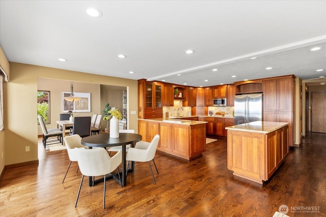 10300 64th Pl W, Mukilteo, WA 98275 - kitchen featuring appliances with stainless steel finishes, recessed lighting, tasteful backsplash, glass insert cabinets, and brown cabinets