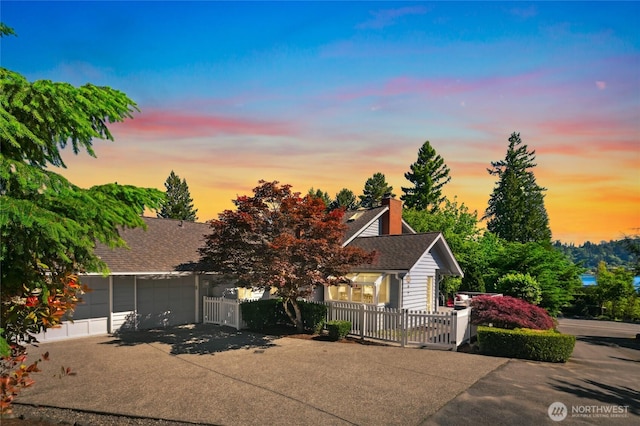 3089 W Lake Sammamish Pkwy NE, Redmond, WA 98052 - view of property hidden behind natural elements featuring concrete driveway, a fenced front yard, an attached garage, and a shingled roof