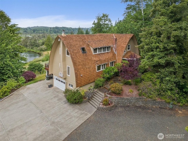 1508 Bloomhardt Rd, Raymond, WA 98577 - view of front facade with a gambrel roof, an attached garage, concrete driveway, and a water view