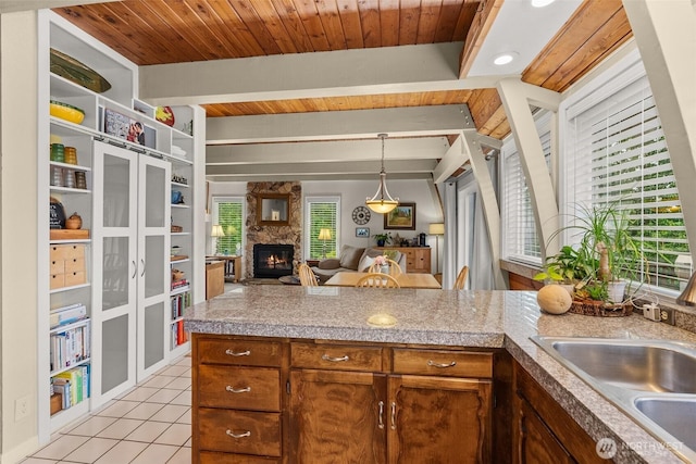 1508 Bloomhardt Rd, Raymond, WA 98577 - kitchen featuring light tile patterned flooring, a stone fireplace, pendant lighting, tile counters, and wooden ceiling