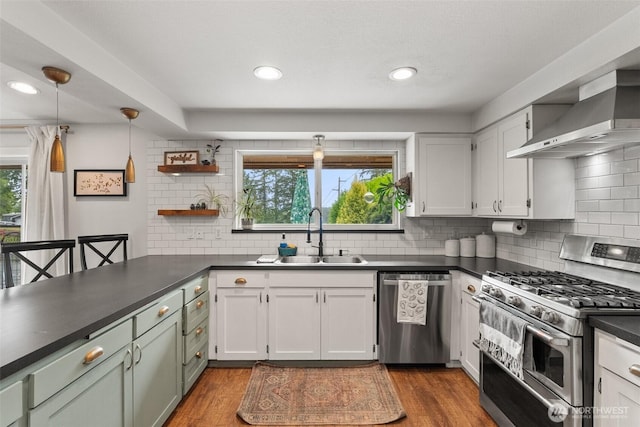 755 Elm St, Raymond, WA 98577 - kitchen featuring stainless steel appliances, wall chimney exhaust hood, dark countertops, healthy amount of natural light, and recessed lighting