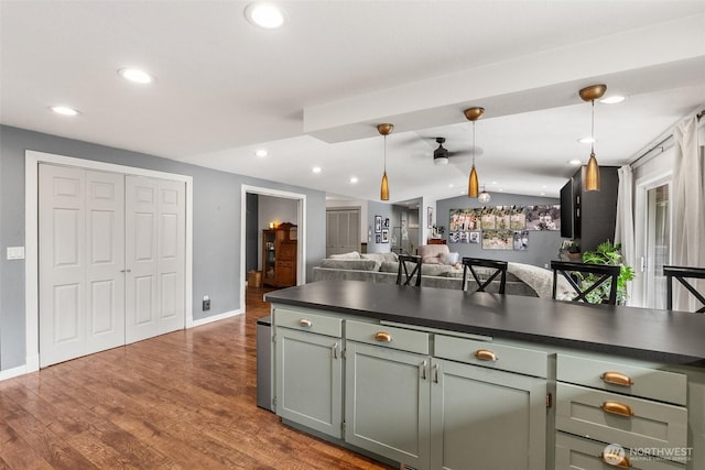 755 Elm St, Raymond, WA 98577 - kitchen featuring dark countertops, dark wood-type flooring, vaulted ceiling, hanging light fixtures, and open floor plan