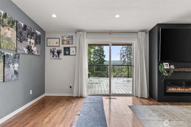 755 Elm St, Raymond, WA 98577 - doorway to outside with wood finished floors, a large fireplace, and recessed lighting