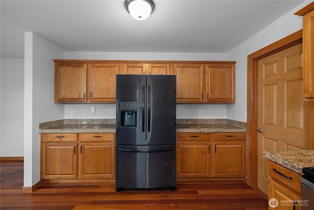 516 Emerald Ct SE, Rainier, WA 98576 - kitchen with black fridge, brown cabinetry, dark wood-type flooring, and dark countertops