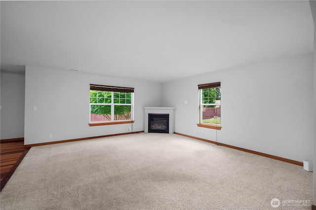 516 Emerald Ct SE, Rainier, WA 98576 - unfurnished living room featuring a glass covered fireplace and carpet floors