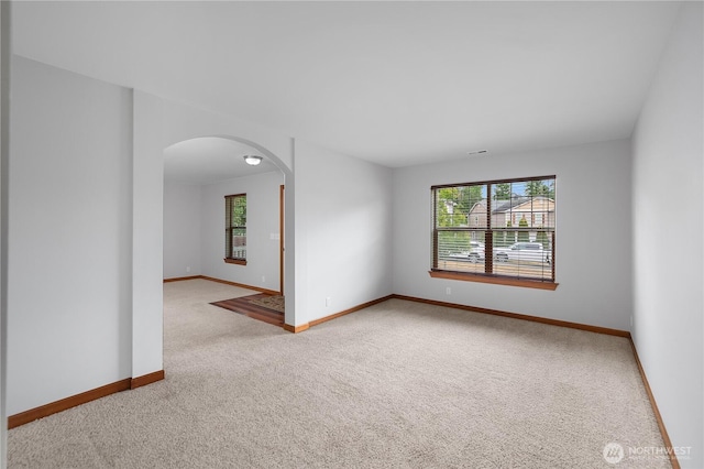 516 Emerald Ct SE, Rainier, WA 98576 - empty room with arched walkways, healthy amount of natural light, and carpet floors
