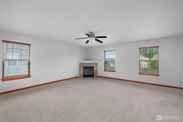 516 Emerald Ct SE, Rainier, WA 98576 - unfurnished living room featuring light colored carpet, a tiled fireplace, and a ceiling fan