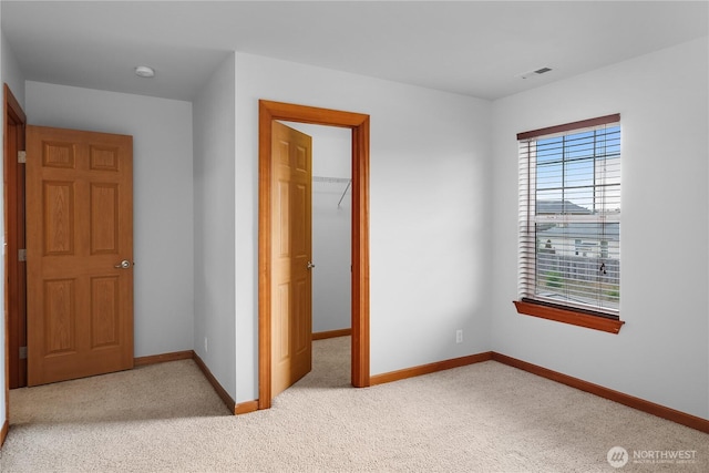 516 Emerald Ct SE, Rainier, WA 98576 - unfurnished bedroom featuring a walk in closet, light carpet, and a closet